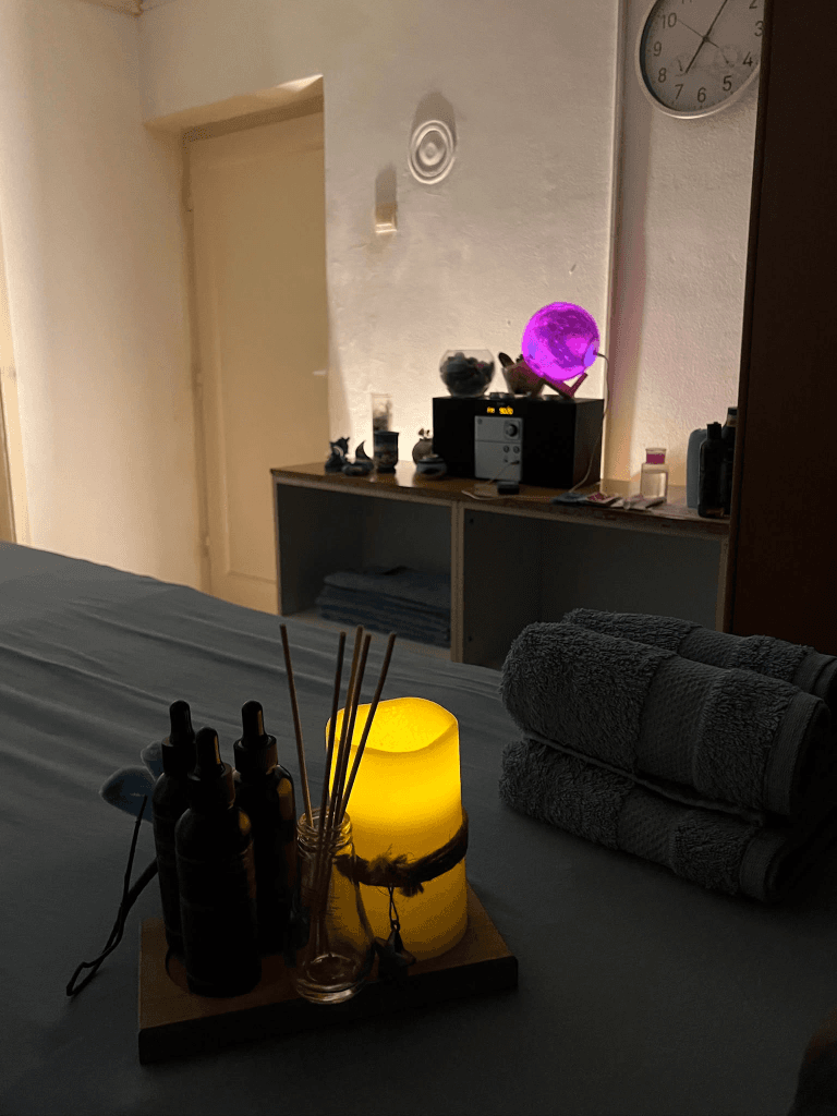 Uredan sto za masažu sa peškirima, difuzerom i uljima u salonu Sunshine